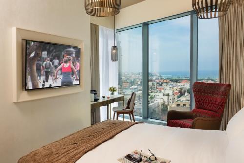 a hotel room with a bed and a tv and window at Hotel Rothschild 22 in Tel Aviv