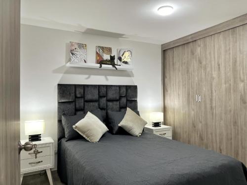 sypialnia z łóżkiem z 2 stolikami nocnymi i 2 lampami w obiekcie Apartamento nuevo contiguo a estación de buses w mieście Manizales