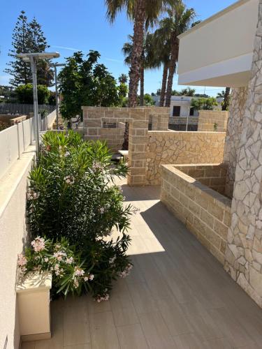 a patio with plants and a stone wall at Salento Appartamento Stella in Marina di Mancaversa