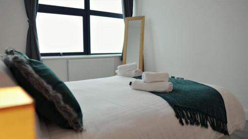 um quarto com uma cama com duas toalhas em Sapphire House Apartments em Telford