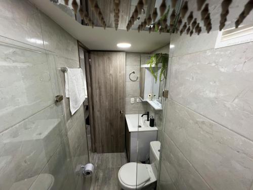 een badkamer met een toilet, een wastafel en een douche bij Apartamento nuevo contiguo a estación de buses in Manizales