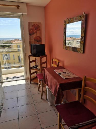 Cette chambre dispose d'une table, d'une télévision et d'une fenêtre. dans l'établissement Le Mariline, à Nice