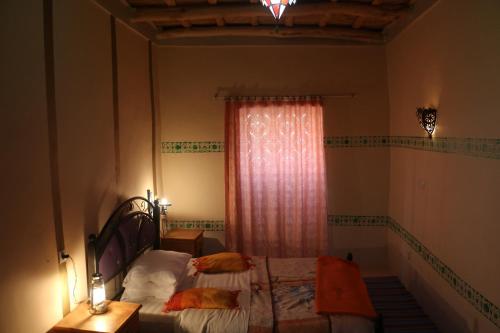 a bedroom with a bed and a window at DAR Moha dades in Aït Ougliff