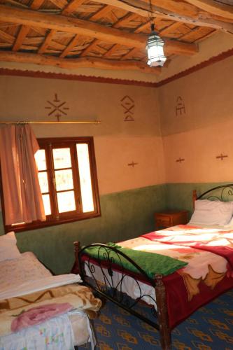 a bedroom with two beds and a window at DAR Moha dades in Aït Ougliff