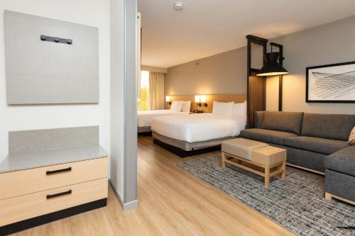 a hotel room with a bed and a couch at Hyatt Place Greenville/Haywood in Greenville