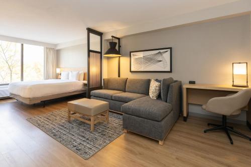 Habitación de hotel con cama, sofá y escritorio en Hyatt Place Greenville/Haywood en Greenville
