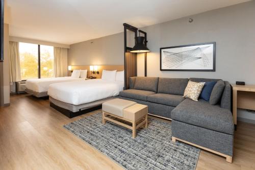 a hotel room with a couch and a bed at Hyatt Place Greenville/Haywood in Greenville