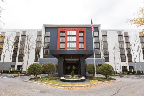 a building with an american flag in front of it at Hyatt Place Greenville/Haywood in Greenville