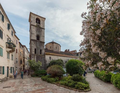 an old building with a tower in a city at Apartman Maestral in Kotor