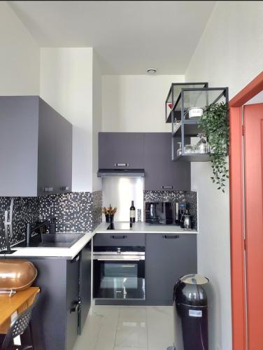 une cuisine avec un évier et une cuisinière four supérieur dans l'établissement Ravissant appartement entièrement rénové T2, proche de la rue Saint Catherine, à Bordeaux