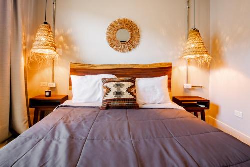 a bedroom with a bed with two lamps and a mirror at Villa Sueño Azul - Playa Venao in Playa Venao