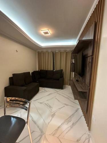a living room with a couch and a television at Apartamento confortável in Boa Vista