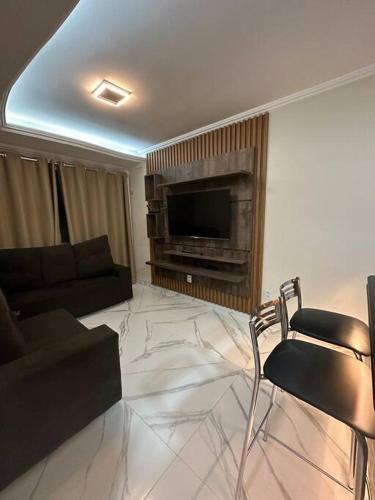 a living room with a couch and a television at Apartamento confortável in Boa Vista