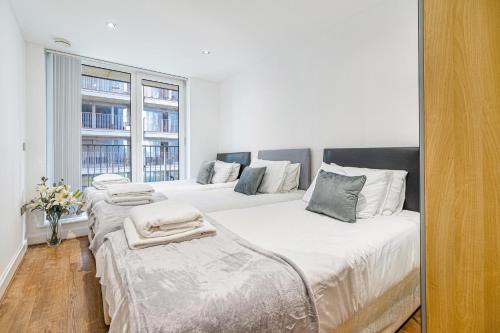 a bedroom with two beds with towels on them at EXCEL LONDON MAJESTIC APARTMENT in London