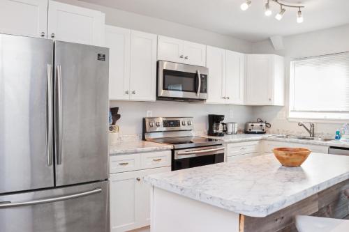 a kitchen with white cabinets and a stainless steel refrigerator at Sunset Blvd by Pristine Properties Vacation Rentals in Saint Joe Beach