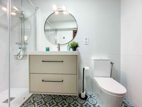 W łazience znajduje się umywalka, toaleta i lustro. w obiekcie COSY FLATS 1ª LINEA VISTAS ESPECTACULARES w Alicante