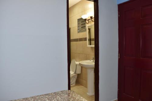 baño con aseo y puerta roja en Apartamentos Alta Vista en David