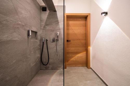 a bathroom with a shower with a glass door at DasKöniglich Luxury Alpine Chalet - Mühlbach am Hochkönig in Mühlbach am Hochkönig