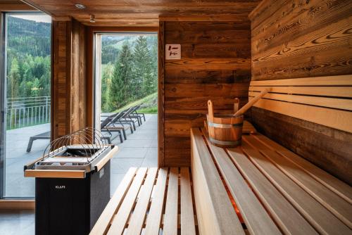 a row of benches in a room with a window at DasKöniglich Luxury Alpine Chalet - Mühlbach am Hochkönig in Mühlbach am Hochkönig