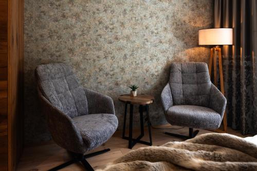 two chairs and a table in a room at DasKöniglich Luxury Alpine Chalet - Mühlbach am Hochkönig in Mühlbach am Hochkönig