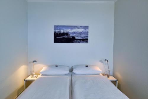 1 dormitorio con 2 camas y una foto en la pared en Strandhochhaus SG04, en Cuxhaven