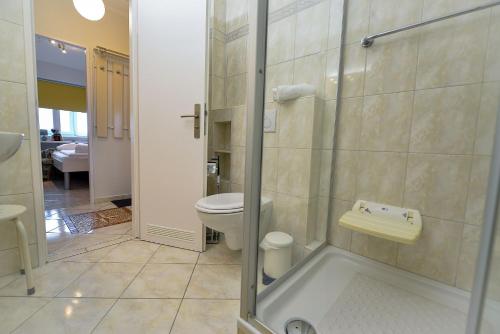 La salle de bains est pourvue de toilettes et d'une douche en verre. dans l'établissement Strandhochhaus SG04, à Cuxhaven