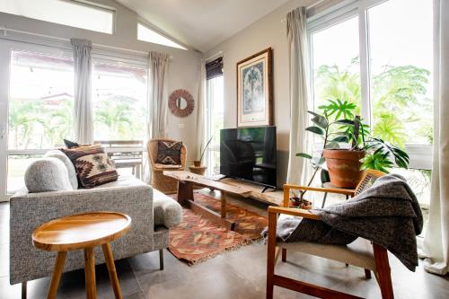 a living room with a couch and a tv at Villa Sueño Azul - Playa Venao in Playa Venao