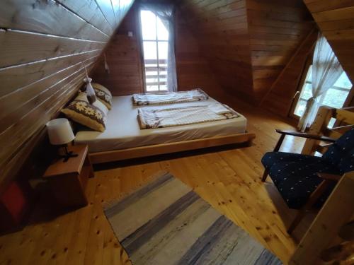 een slaapkamer met een bed in een houten hut bij Deus 2 brvnara Tara in Jezdići