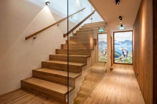 a staircase in a house with a glass wall at DasKöniglich Luxury Alpine Chalet - Mühlbach am Hochkönig in Mühlbach am Hochkönig