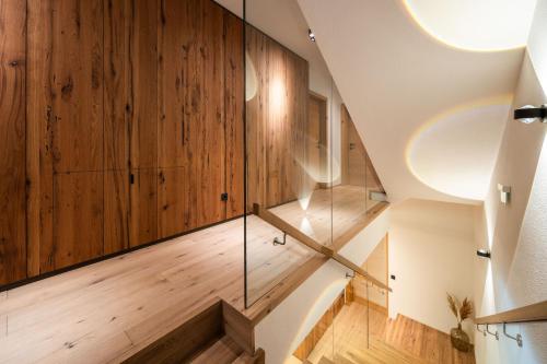a staircase with wood paneling and a glass wall at DasKöniglich Luxury Alpine Chalet - Mühlbach am Hochkönig in Mühlbach am Hochkönig