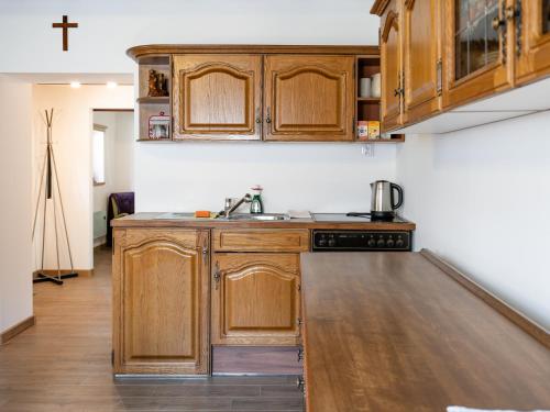 a kitchen with wooden cabinets and a sink at Drevenička v Ďurčinej - Júlia in Ďurčiná