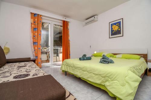 a bedroom with a bed and a couch and a window at Apartment Tonci in Igrane