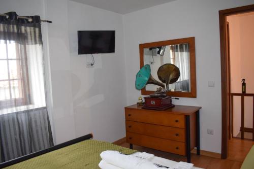 a bedroom with a bed and a mirror and a dresser at Casa da Escola By Villa Regalenga in Talhada