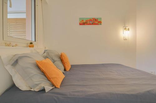 une chambre avec un lit avec des oreillers et une fenêtre dans l'établissement 301 - Bel appartement calme, proche plage, à Menton