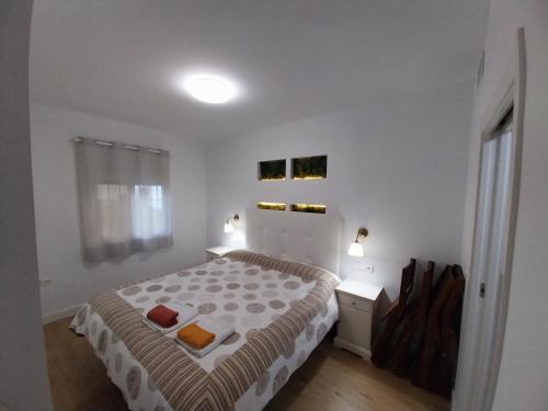 a white bedroom with a bed and a window at Torremolinos Playa Carihuela in Torremolinos