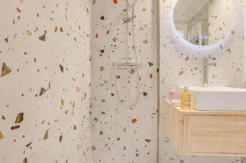 La salle de bains est pourvue d'une douche avec un mur en pierre. dans l'établissement 301 - Bel appartement calme, proche plage, à Menton