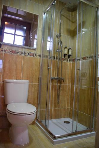 a bathroom with a toilet and a glass shower at Casa da Escola By Villa Regalenga in Talhada