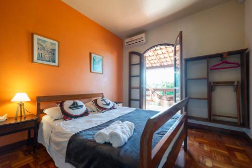 een slaapkamer met een bed, een bureau en een raam bij POUSADA RECANTO DA LADEIRA in Paraty