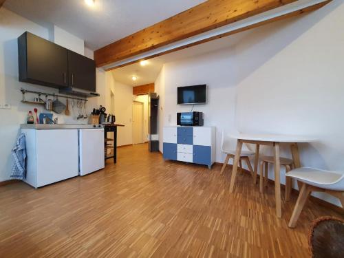 a kitchen and living room with a table and chairs at Boardinghouse Steinen in Steinen