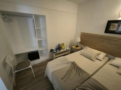 a bedroom with a bed and a window and a chair at Apartamentos La Florida in Puerto del Carmen