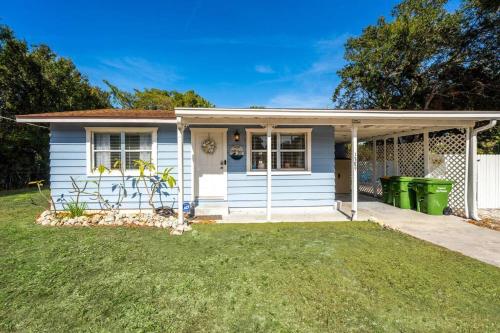 a white house with a green trash can in the yard at 10 min Lido Key Beach ~Coastal Cabana Hideout in Sarasota