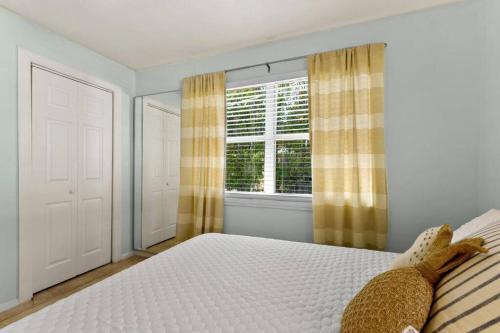 a bedroom with a white bed and a window at 10 min Lido Key Beach ~Coastal Cabana Hideout in Sarasota