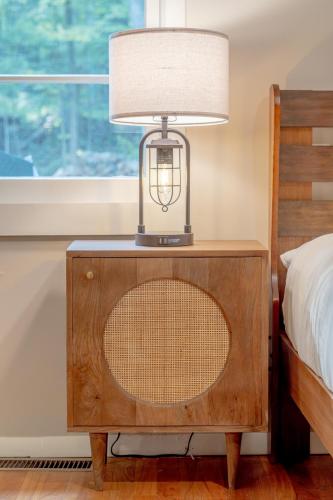 a lamp on a night stand next to a bed at Modern Rustic Escape w/Hot Tub - High Falls Lodge in Saugerties