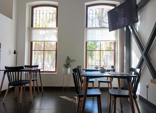 una sala da pranzo con tavolo, sedie e finestre di BHB Hotel Boutique a Santiago
