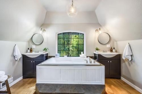 ein großes Bad mit einer großen Badewanne und 2 Waschbecken in der Unterkunft Hillside Cottaga- Private pond, hot tub, game room, by ONP in Port Angeles
