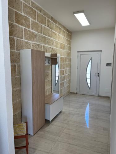 an empty room with a brick wall and a refrigerator at Salento Appartamento Sole in Marina di Mancaversa