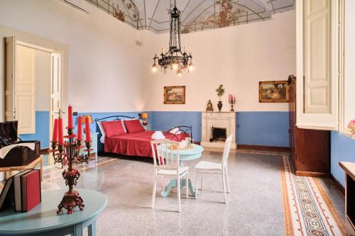 a living room with a red bed and a table at Palazzo Scarciglia in Minervino di Lecce
