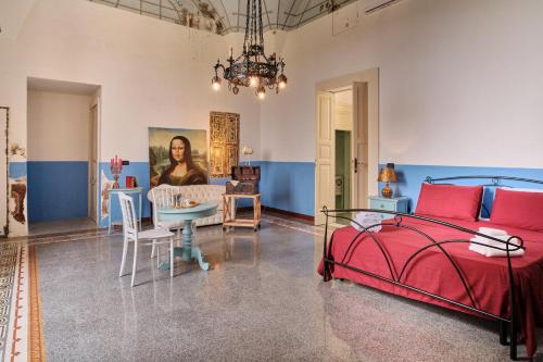 a bedroom with a red bed and a dining room at Palazzo Scarciglia in Minervino di Lecce