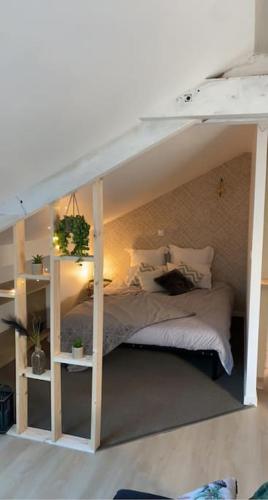 - une chambre dotée d'un lit avec un cadre blanc dans l'établissement Appartement cosy indépendant, à Châteauroux
