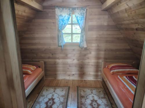 a room with two beds and a window at Aurora Tara 1 in Bajina Bašta
